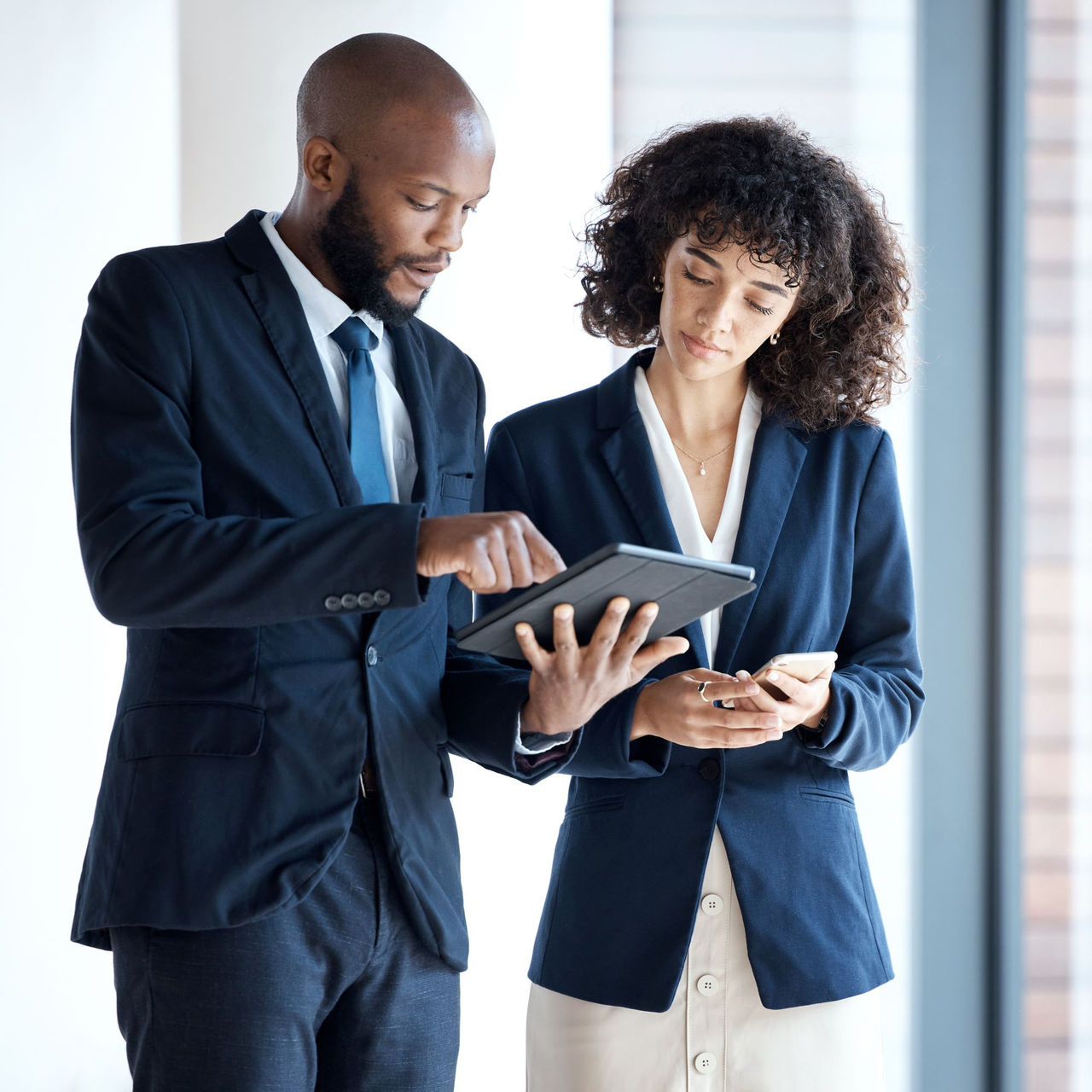 Man and woman looking at tablet in office space