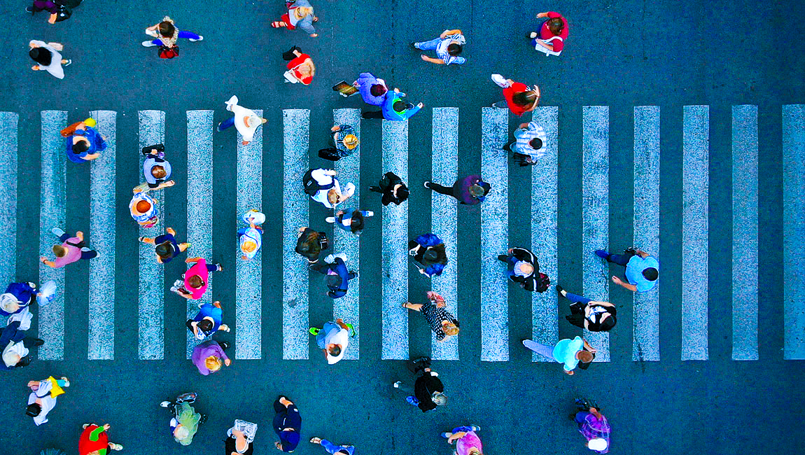 Aerial view of people crossing city crosswalk